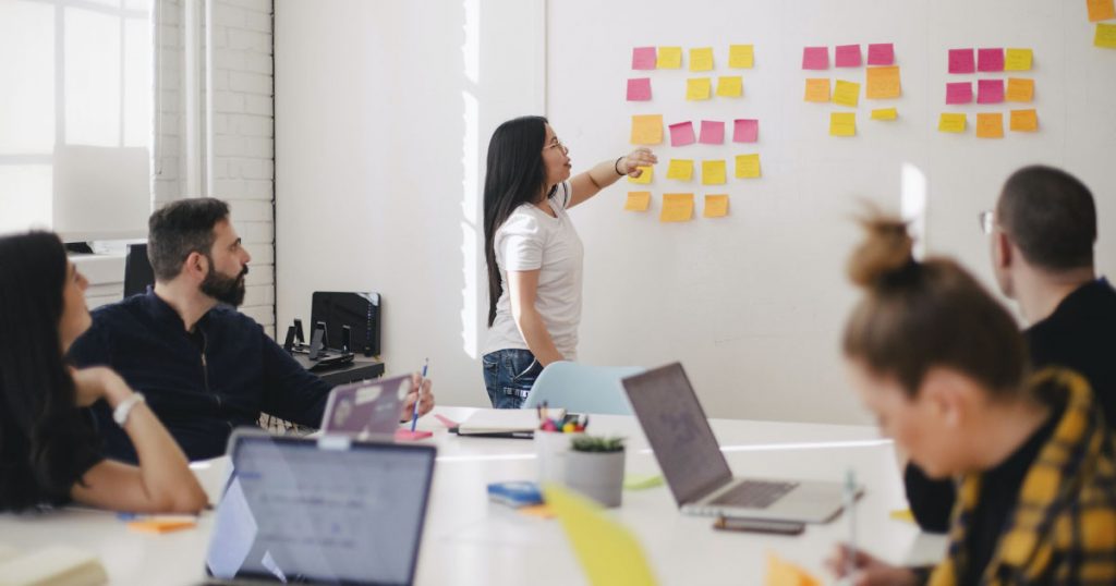 Equipo de 6 personas en una oficina a la luz del día, planificando estrategias empresariales. Plataforma de inversiones